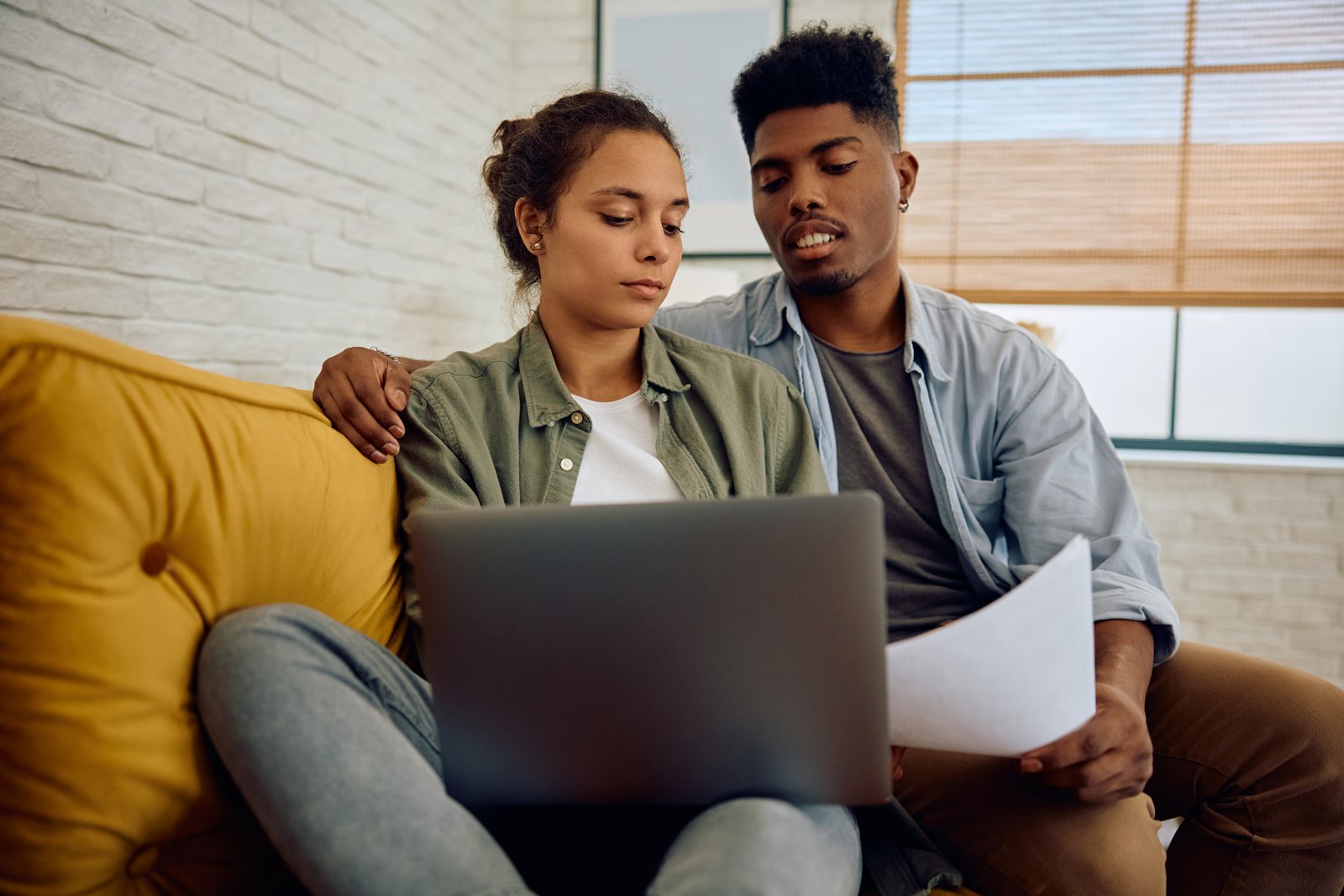 Person checking their credit score on a laptop at a kitchen table