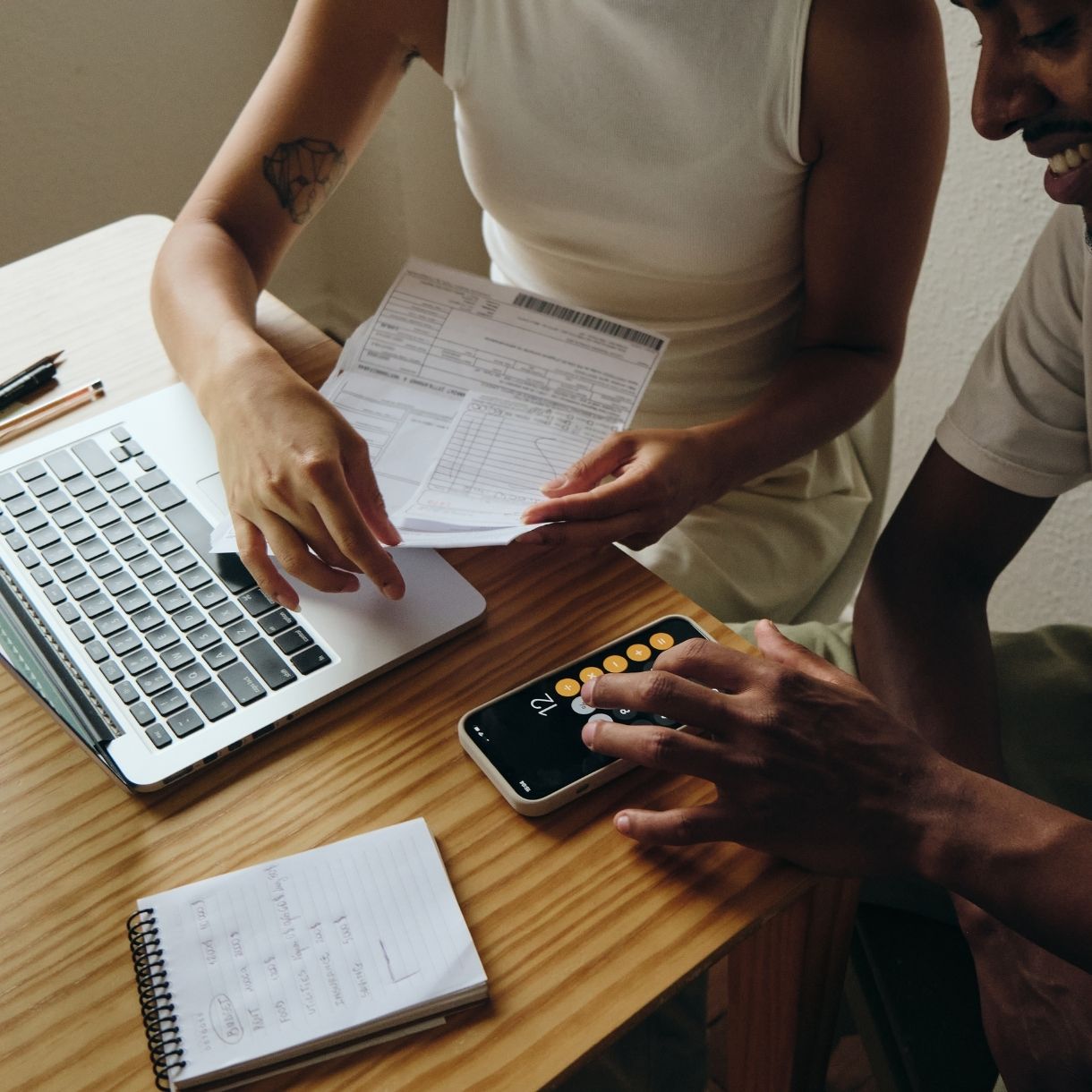 Couple sitting at a table calculating finances.